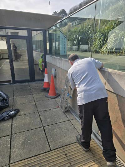 worker scraping paint off the walls at the Langmoor Room, Lyme Regis